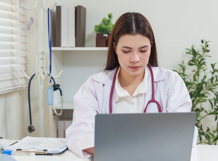 Physician reviewing patient medical history at a clinic desk